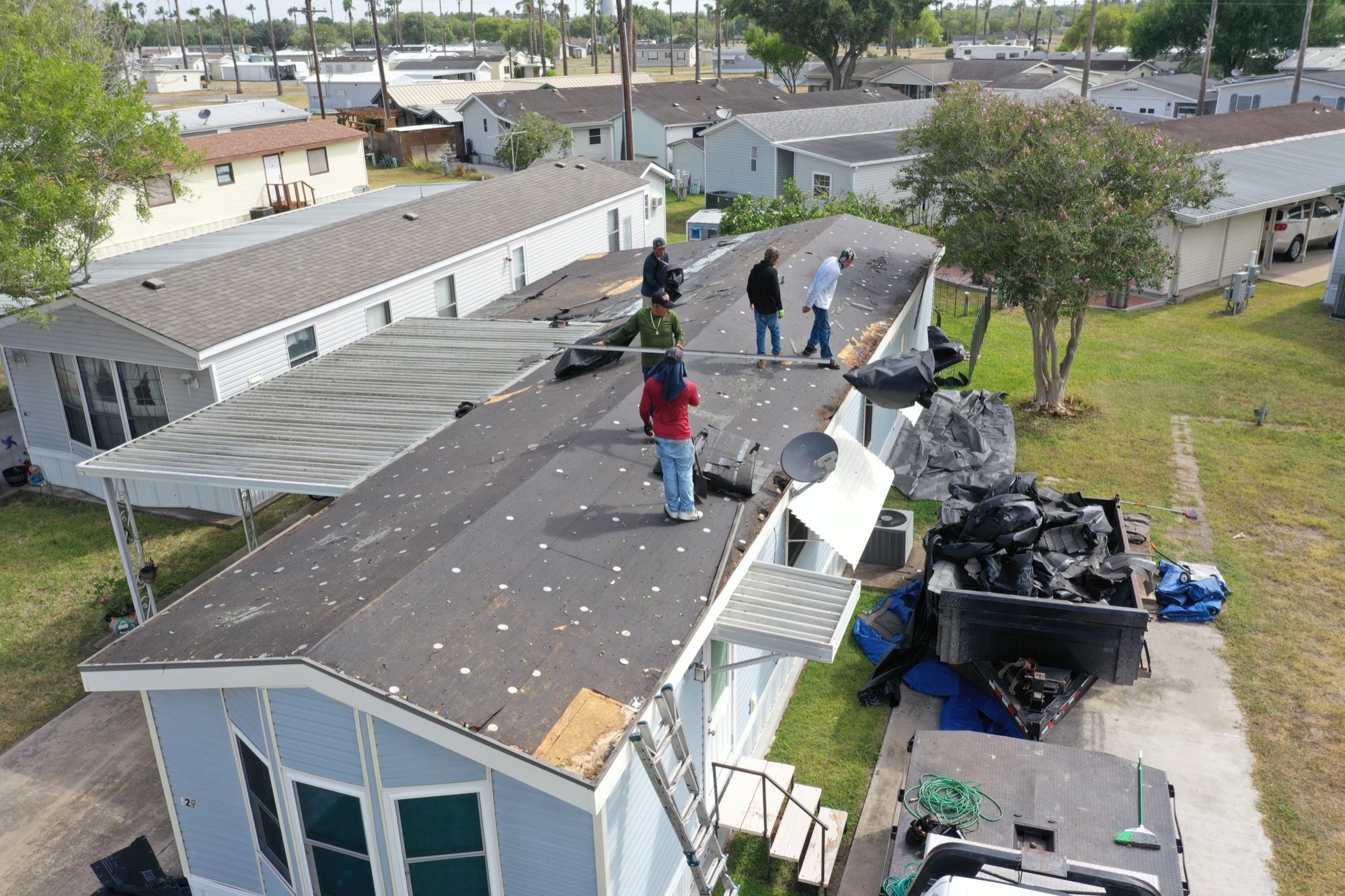 Texas Contractors crew tearing off the old roof on a mobile home in the Rio Grande Valley